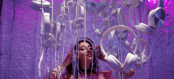 Image of young woman surrounded by headphones